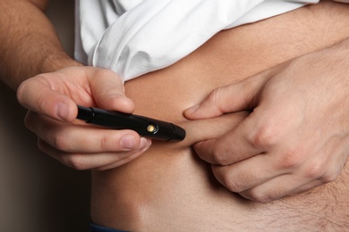 Man doing insulin injection in stomach, closeup. Diabetes disease