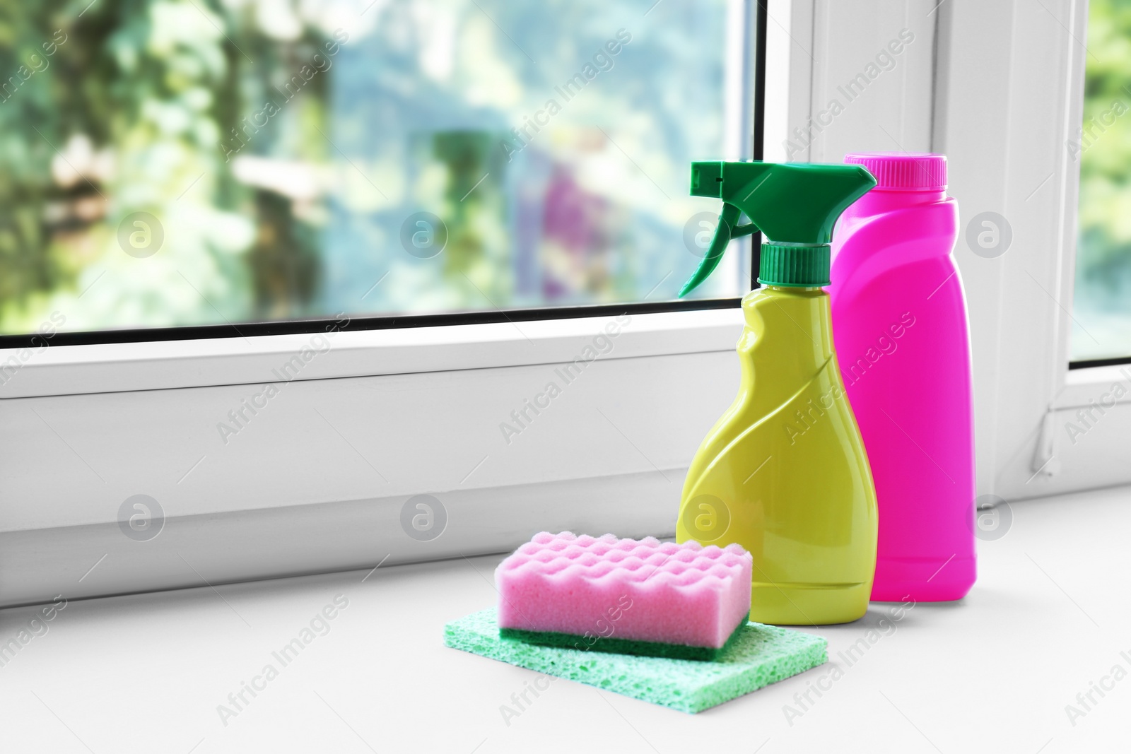 Photo of Cleaning supplies and sponges on window sill indoors, space for text
