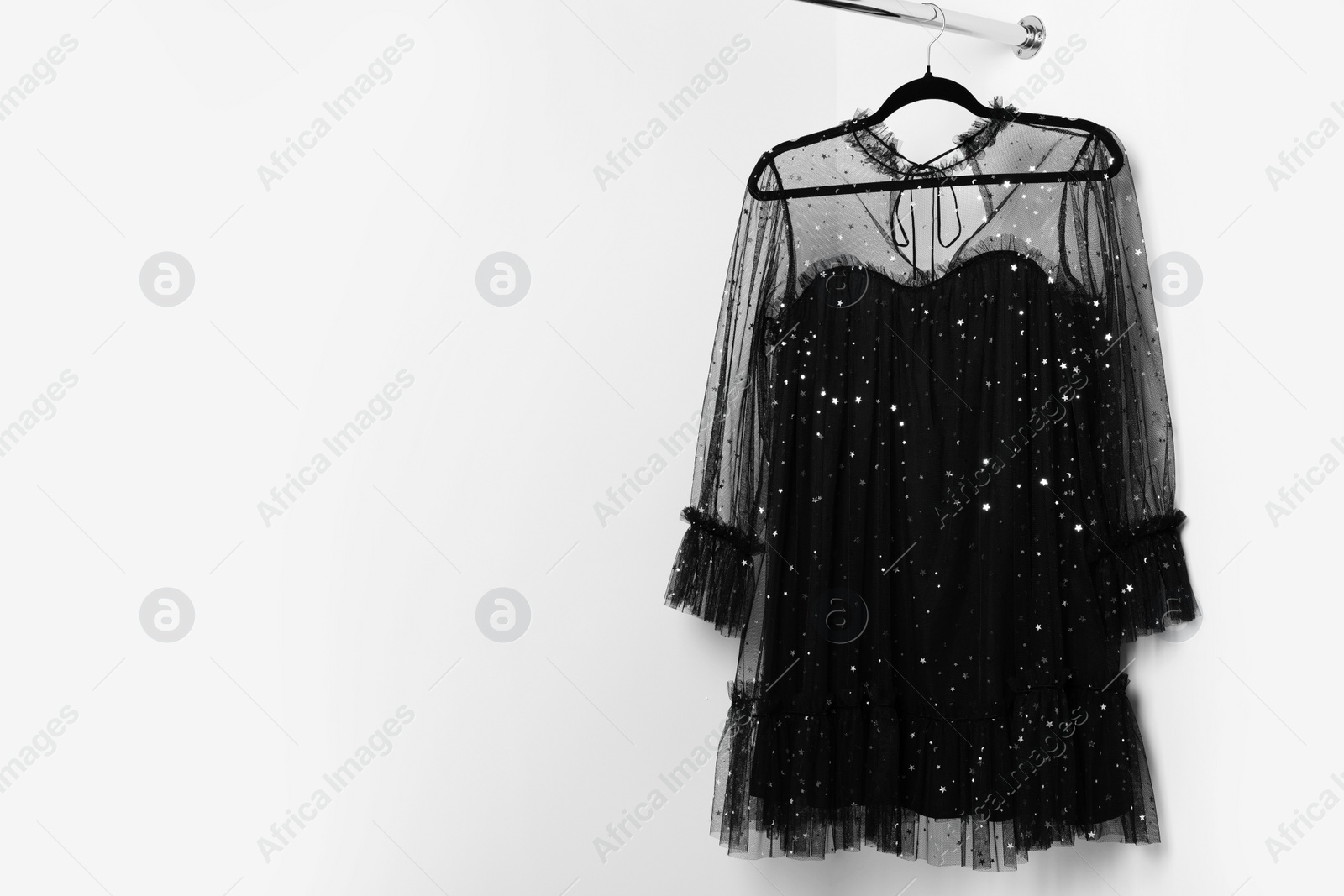 Photo of Beautiful black women's party dress on hanger, space for text. Stylish trendy clothes for high school prom