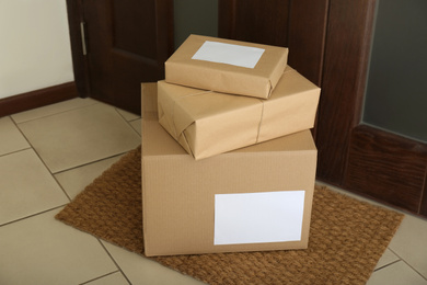 Photo of Parcels on rug near door. Delivery service