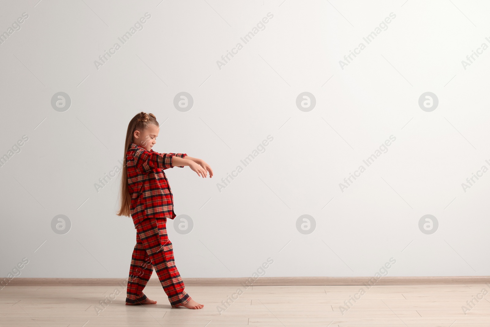 Photo of Girl in pajamas sleepwalking indoors, space for text