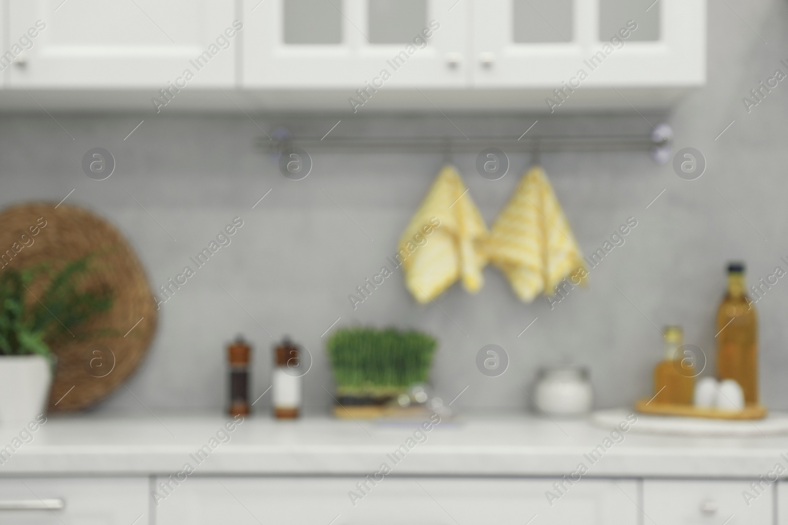 Photo of White cosy kitchen with furniture, blurred view. Interior design