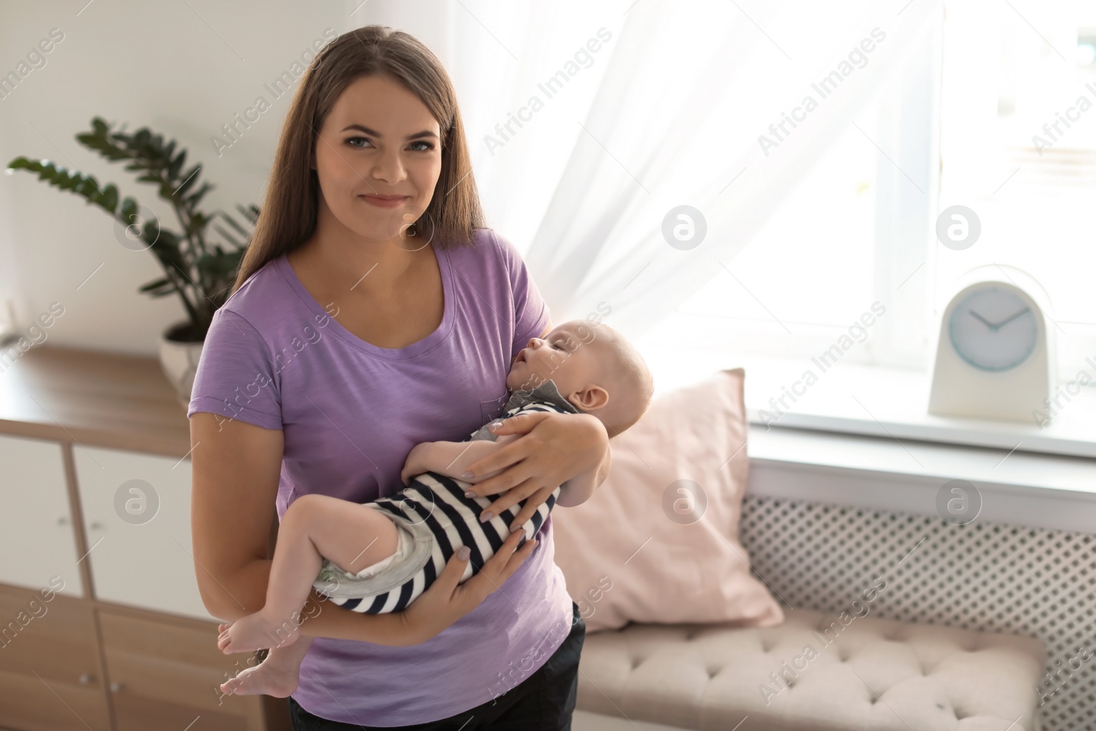 Photo of Mother with her sleeping baby at home