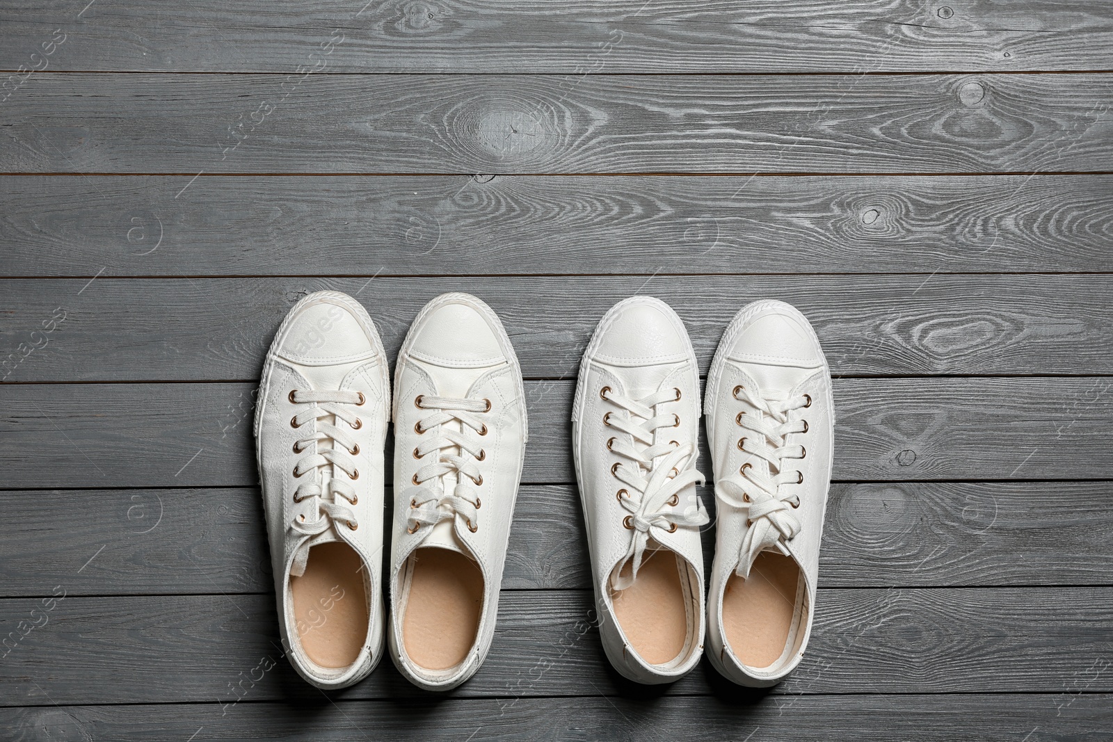 Photo of White sneakers and space for text on wooden background, top view. Stylish shoes