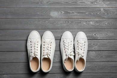 Photo of White sneakers and space for text on wooden background, top view. Stylish shoes