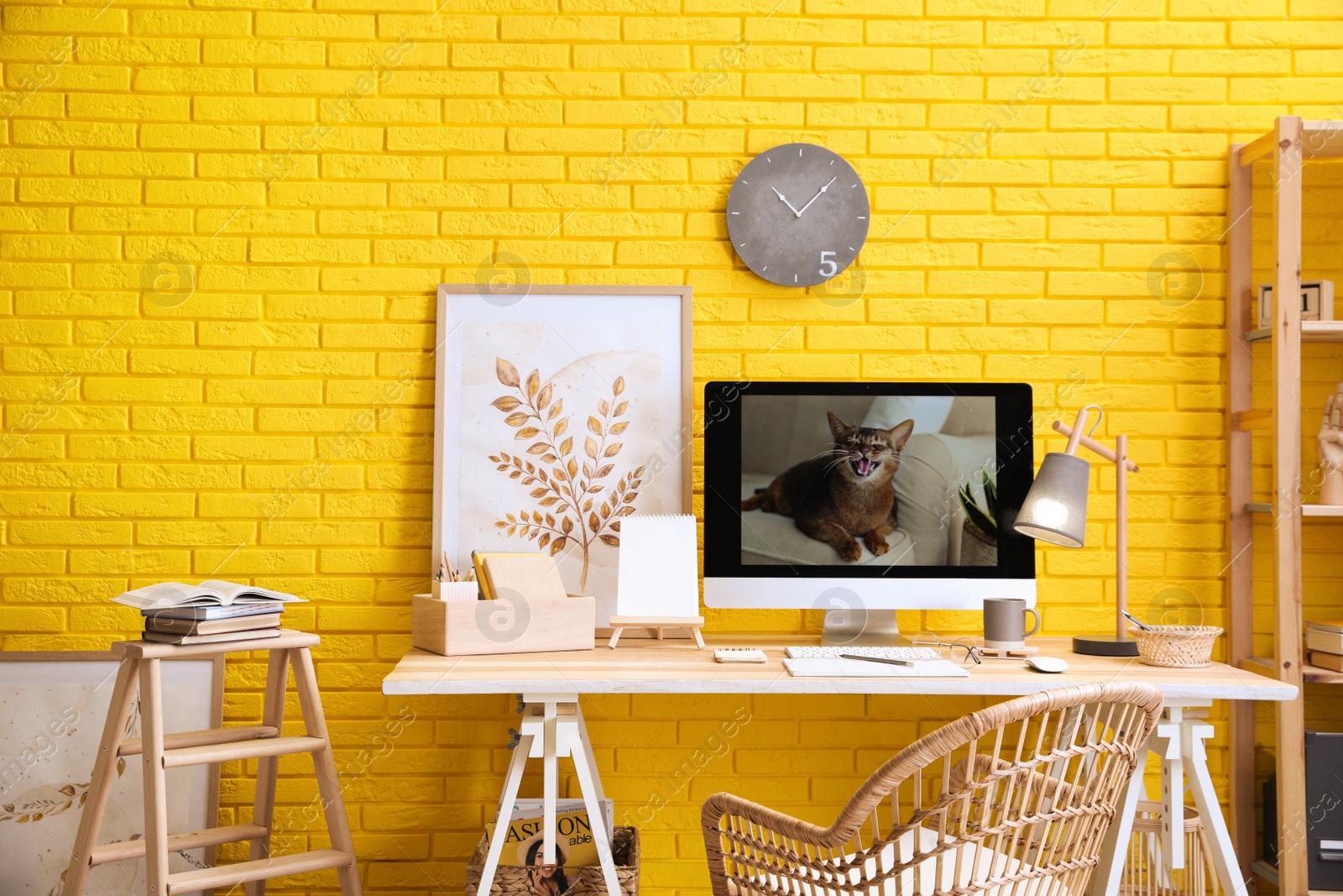 Photo of Stylish home office interior with comfortable workplace near yellow brick wall