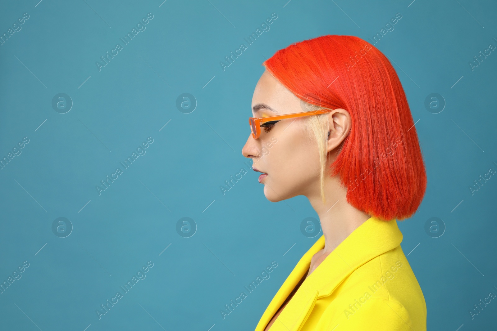 Photo of Beautiful young woman with bright dyed hair on turquoise background, space for text