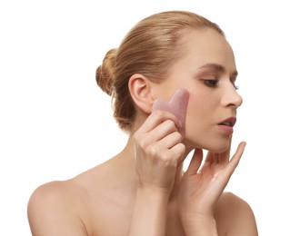 Photo of Beautiful young woman doing facial massage with gua sha tool on white background