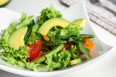 Delicious avocado salad in bowl on table, closeup