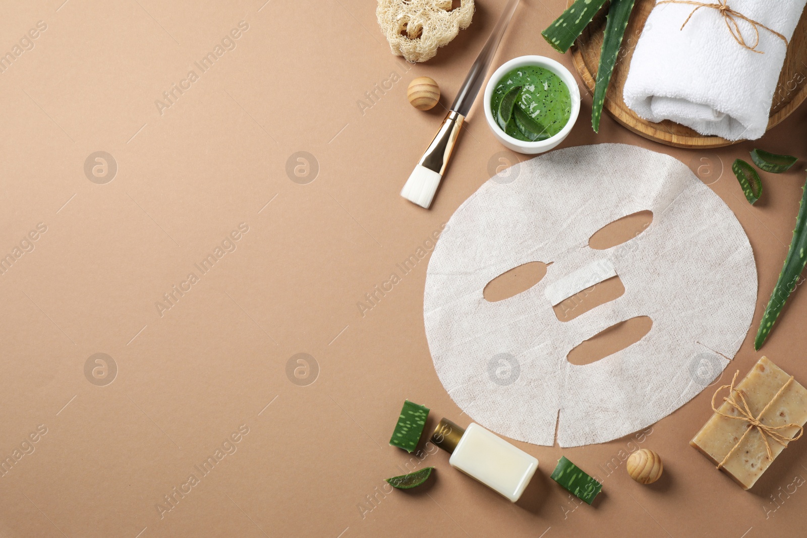 Photo of Flat lay composition with different cosmetic products and aloe on brown background, space for text