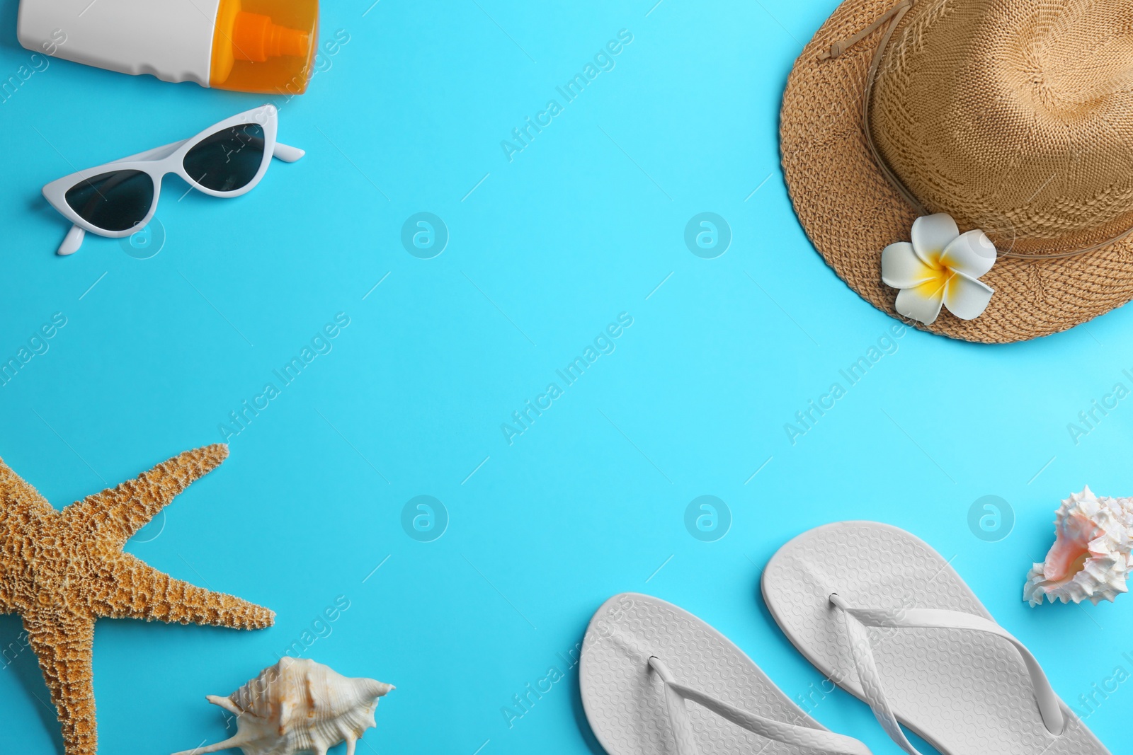 Photo of Frame made with beach accessories on light blue background, flat lay. Space for text