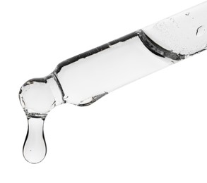 Photo of Dripping clear facial serum from pipette on white background, closeup