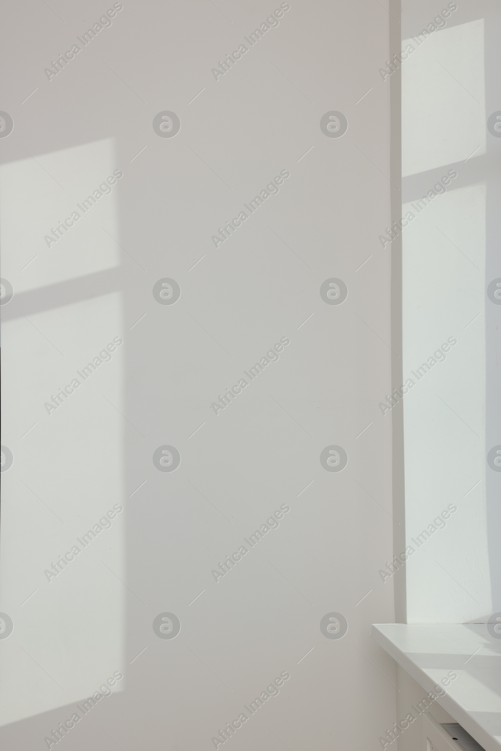 Photo of Light and shadows from window on wall indoors