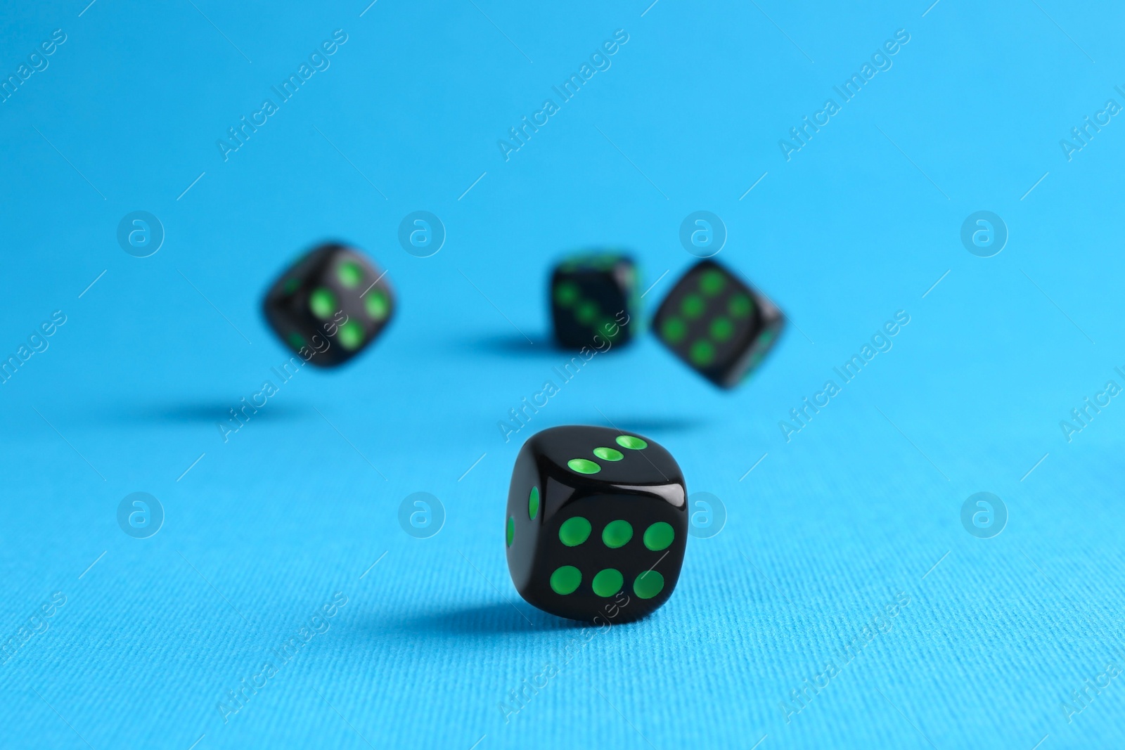 Photo of Many black game dices on light blue background