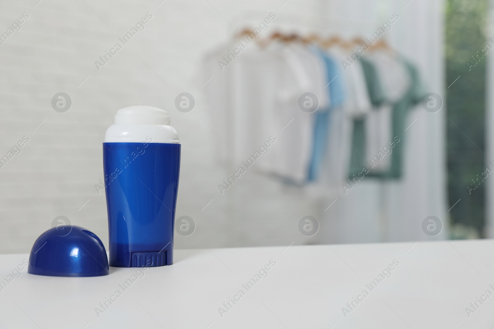 Photo of Deodorant on white table indoors. Space for text