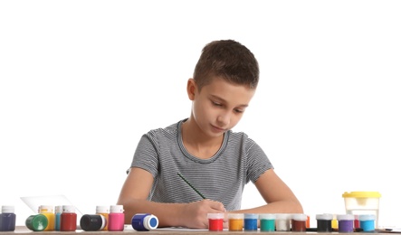 Photo of Cute child painting picture at table on white background