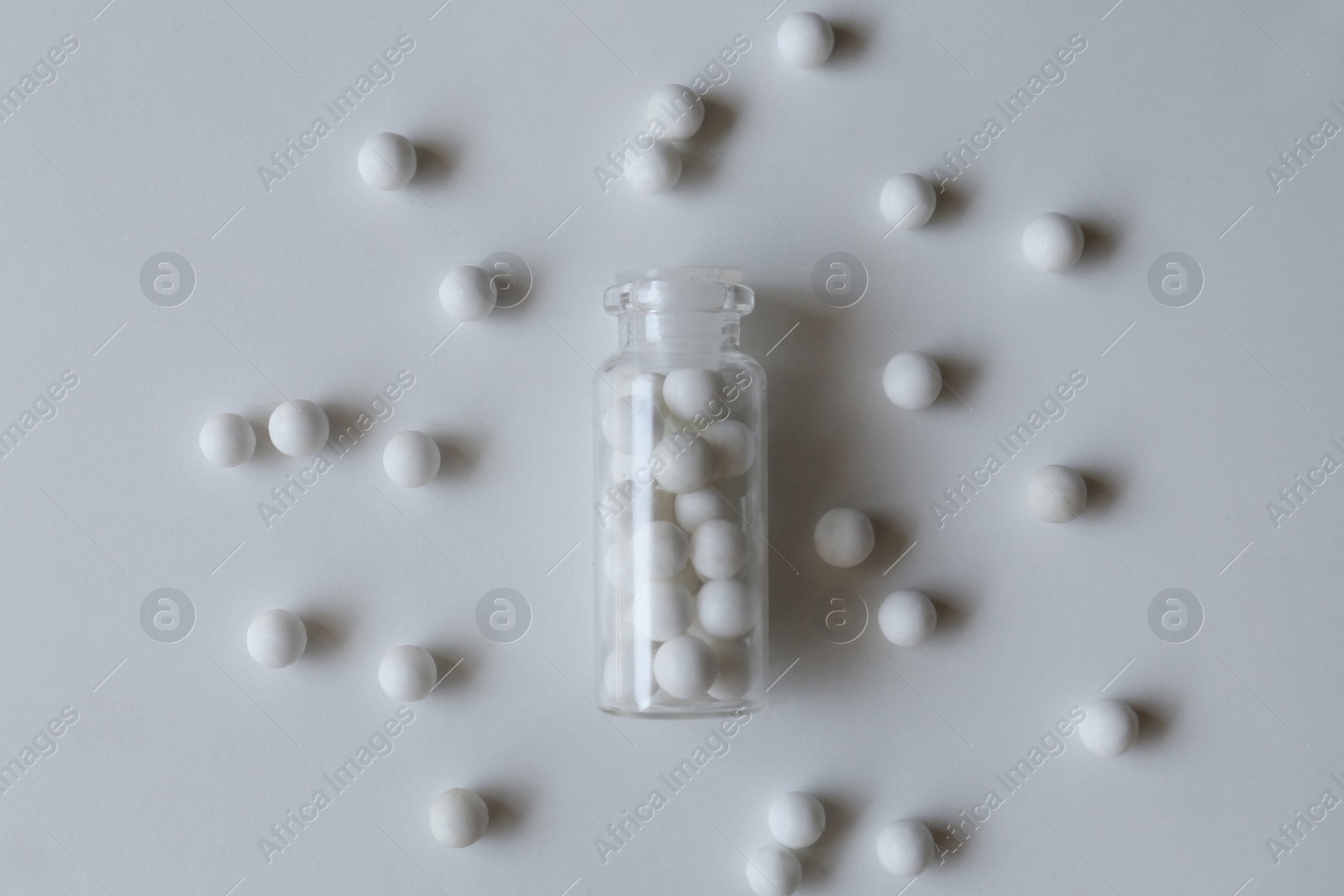 Photo of Bottle with homeopathic remedy on white background, flat lay