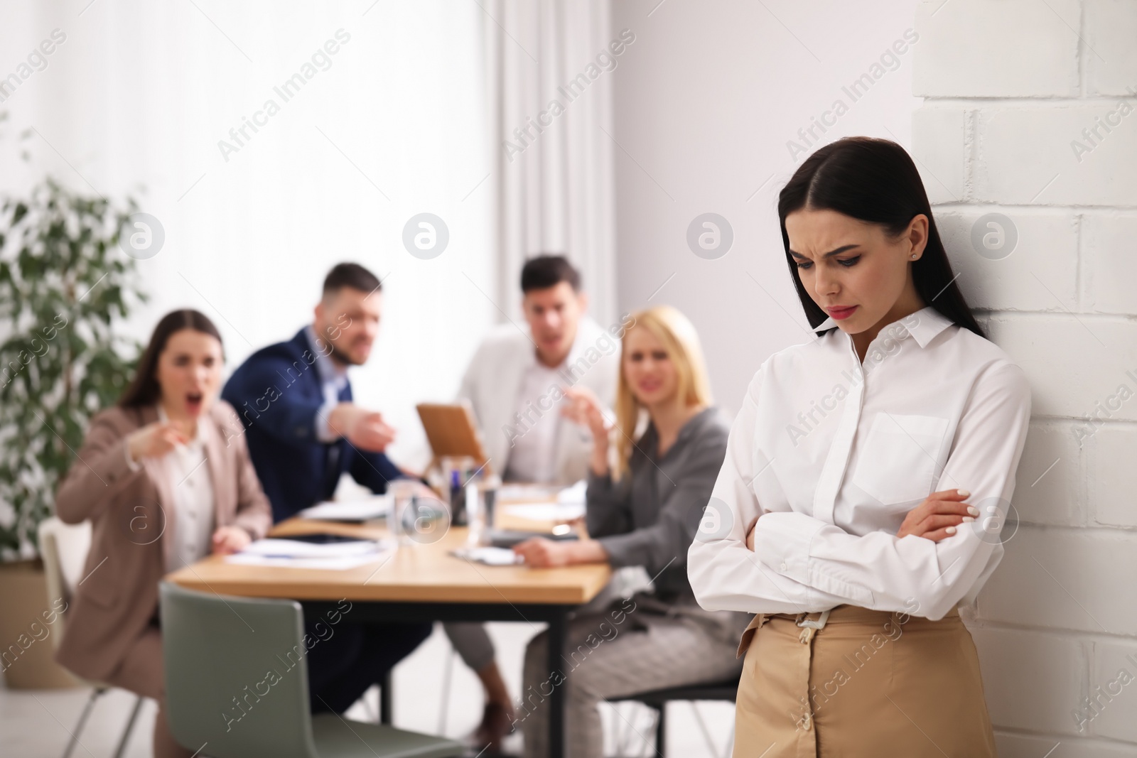 Photo of Coworkers bullying their colleague in office, space for text