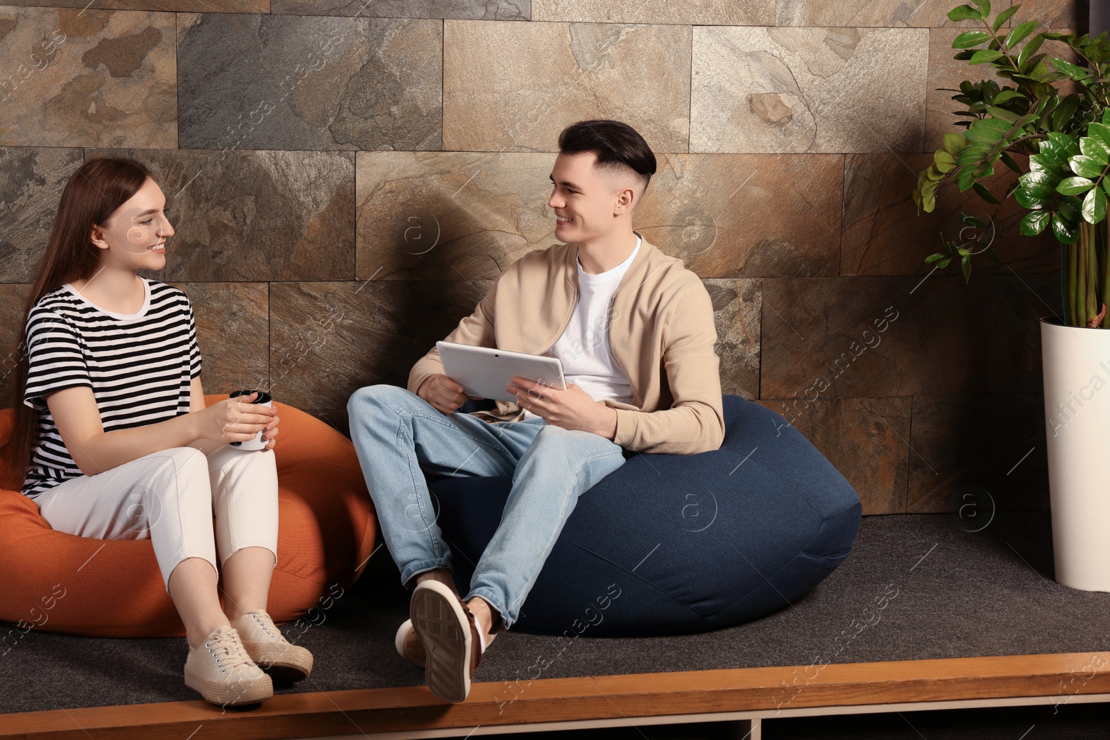 Photo of Office employees enjoying break together in recreation room at work