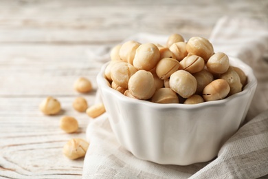 Bowl with shelled organic Macadamia nuts and space for text on white table