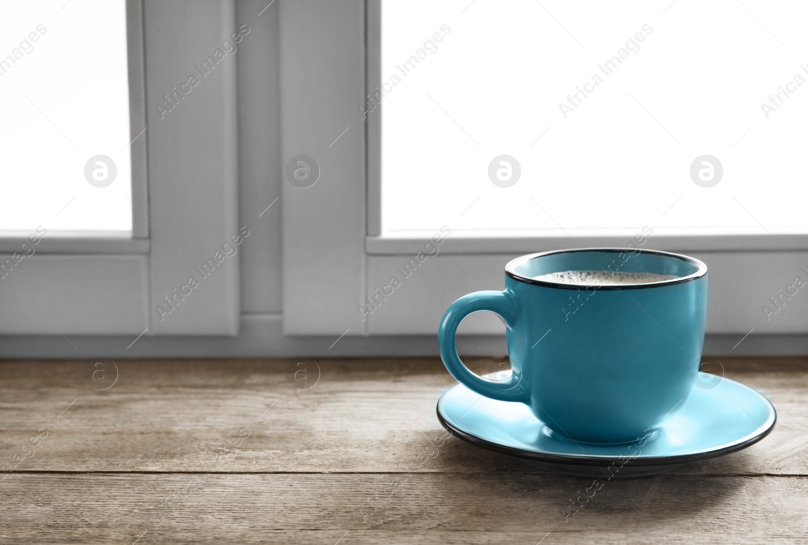 Photo of Cup of hot winter drink on wooden sill near window, space for text. Cozy season