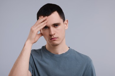 Portrait of sad man on grey background