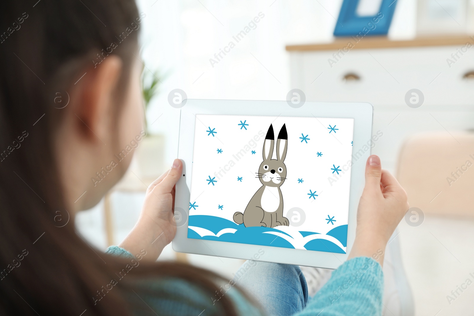 Image of Little girl holding tablet with cute drawing at home. Child art