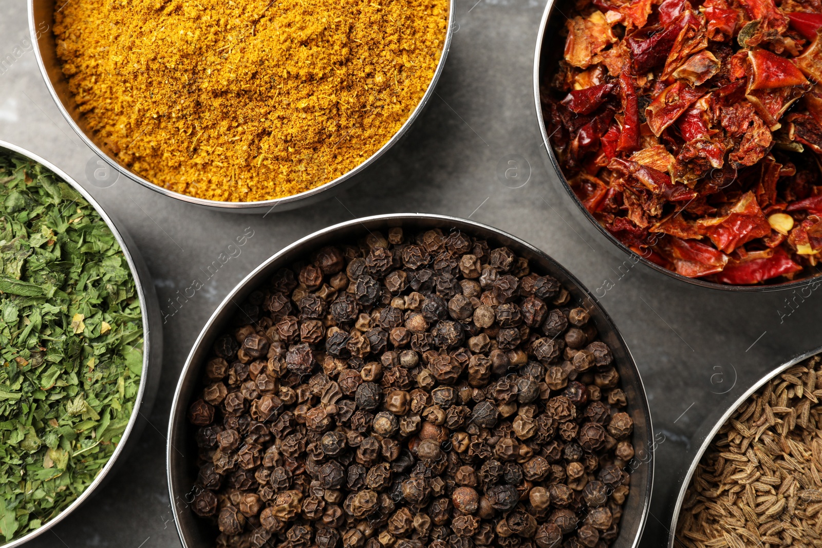 Photo of Bowls with different spices on grey marble table, flat lay