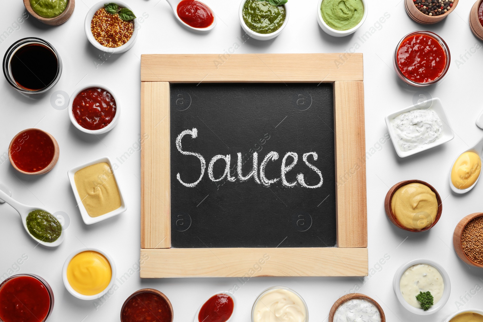 Photo of Small blackboard with word Sauces and different dressings on white background, flat lay