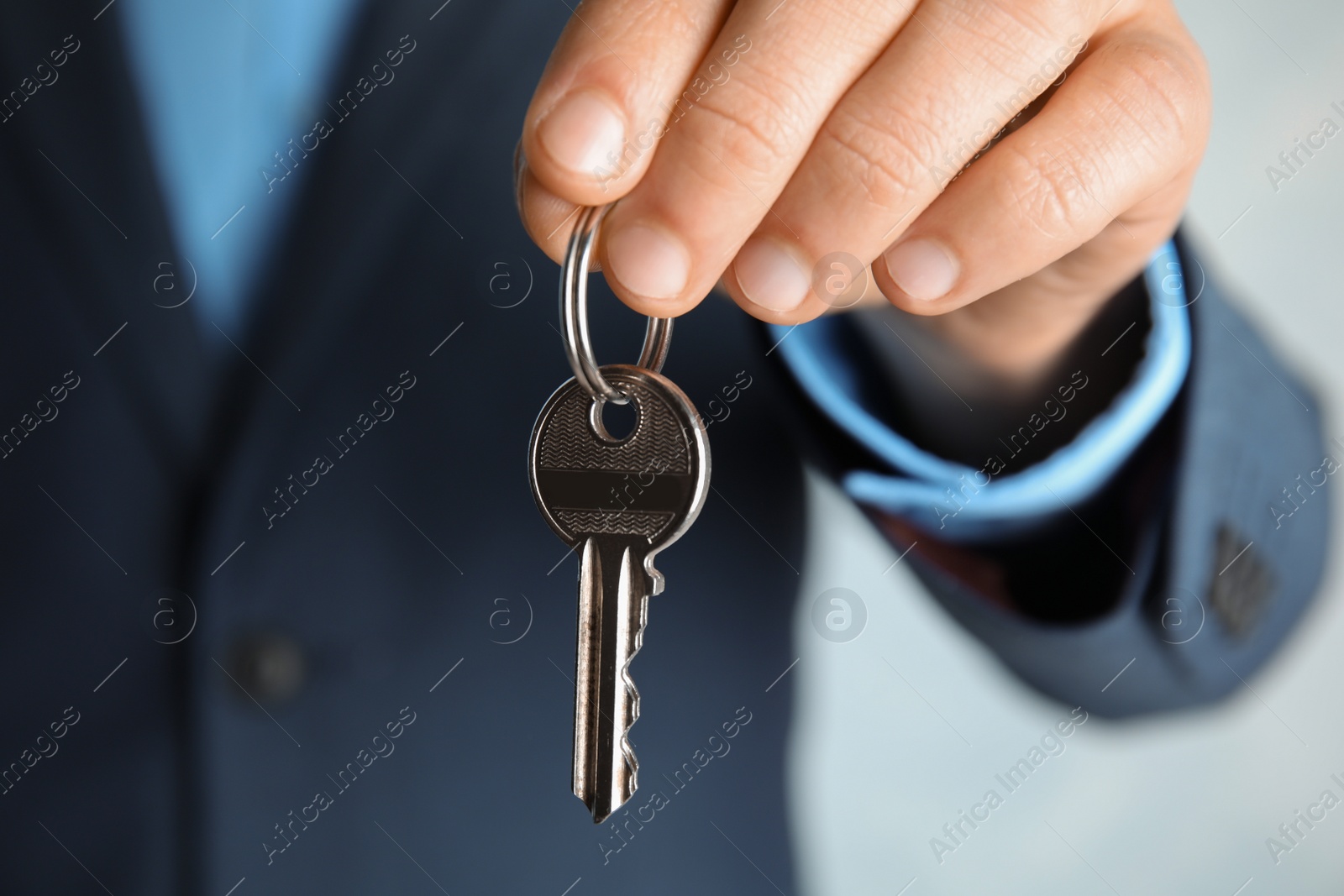 Photo of Young man holding key on color background, closeup