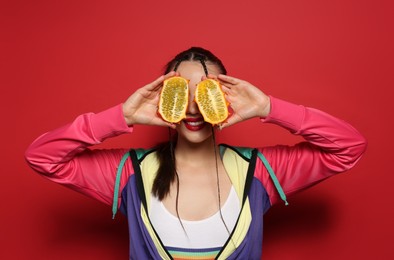 Photo of Young woman with fresh kiwano on red background. Exotic fruit