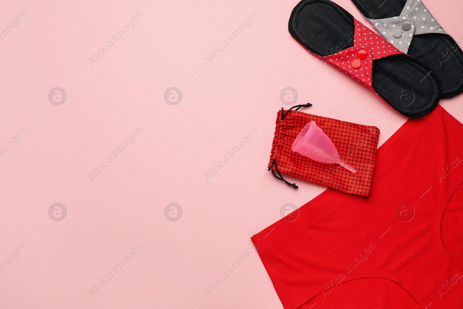 Photo of Women's underwear, reusable cloth pads and menstrual cup on pink background, flat lay. Space for text