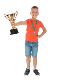 Photo of Happy boy with golden winning cup and medal isolated on white
