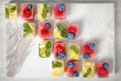 Flat lay composition with fruit and berry ice cubes on table