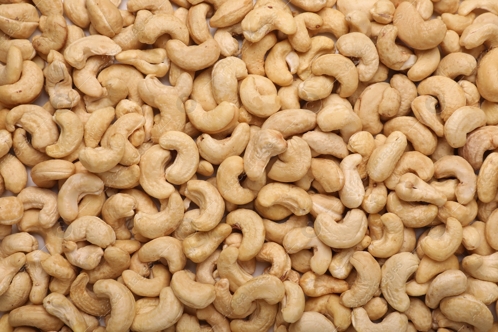 Photo of Many tasty cashew nuts as background, top view