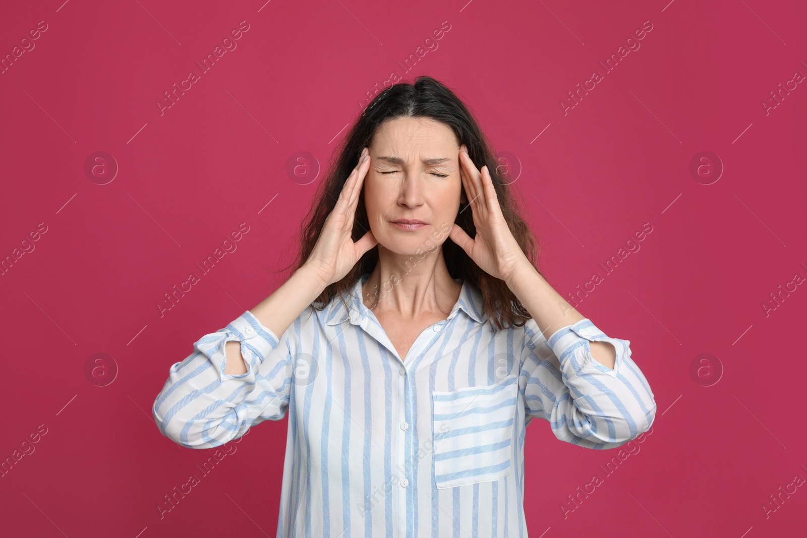 Photo of Mature woman suffering from headache on pink background