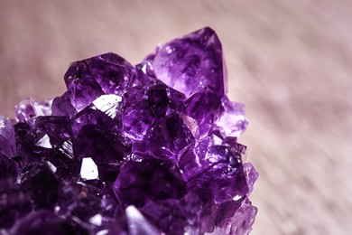Beautiful purple amethyst gemstone on blurred background, closeup