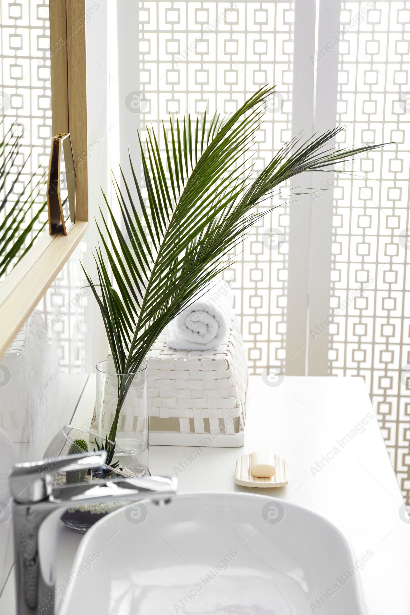 Photo of Tropical palm leaves in stylish bathroom interior