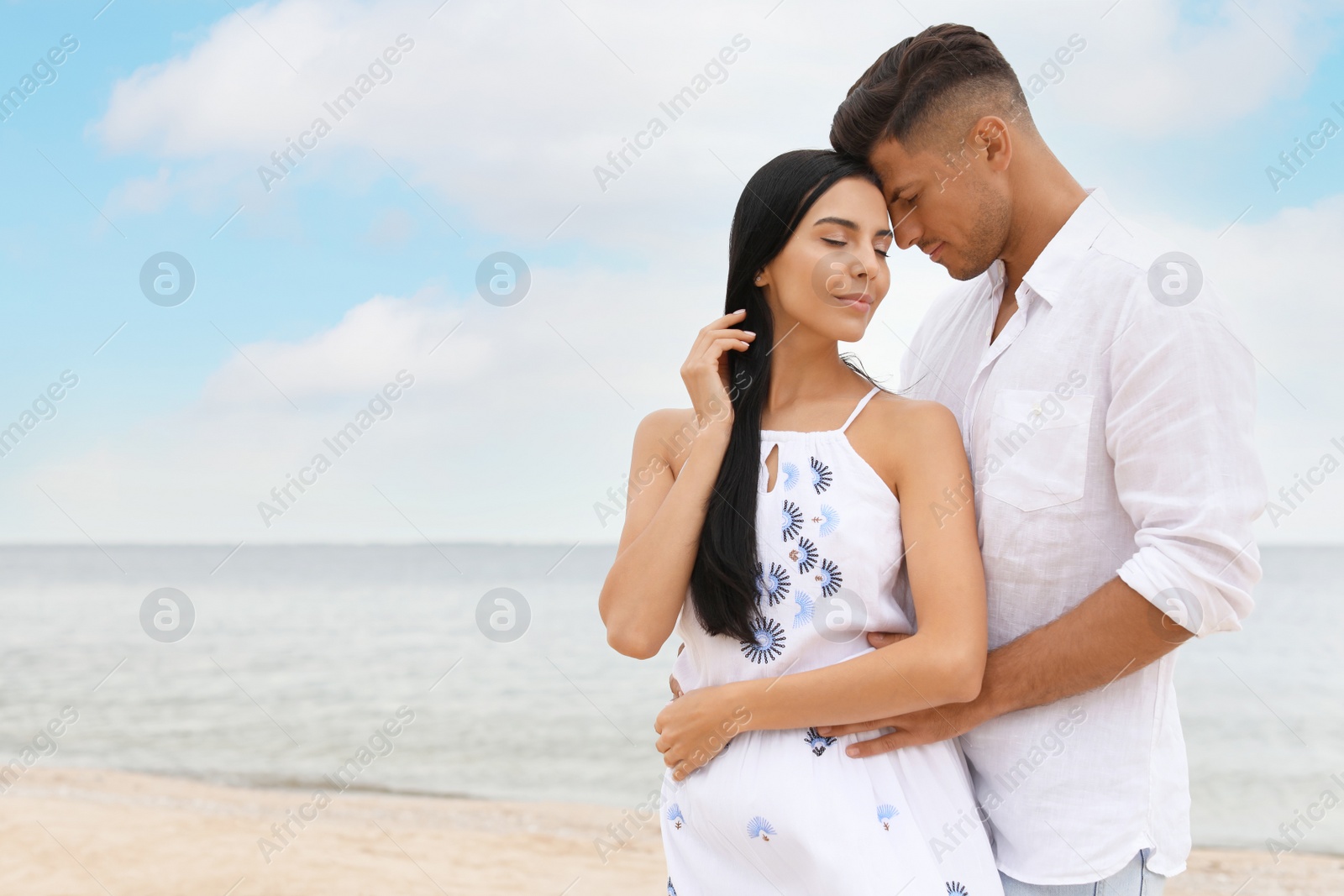 Photo of Lovely couple spending time together on beach. Space for text