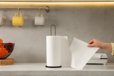 Photo of Woman using paper towels in kitchen, closeup