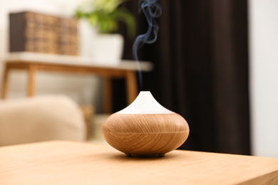 Aroma oil diffuser on wooden table at home. Air freshener