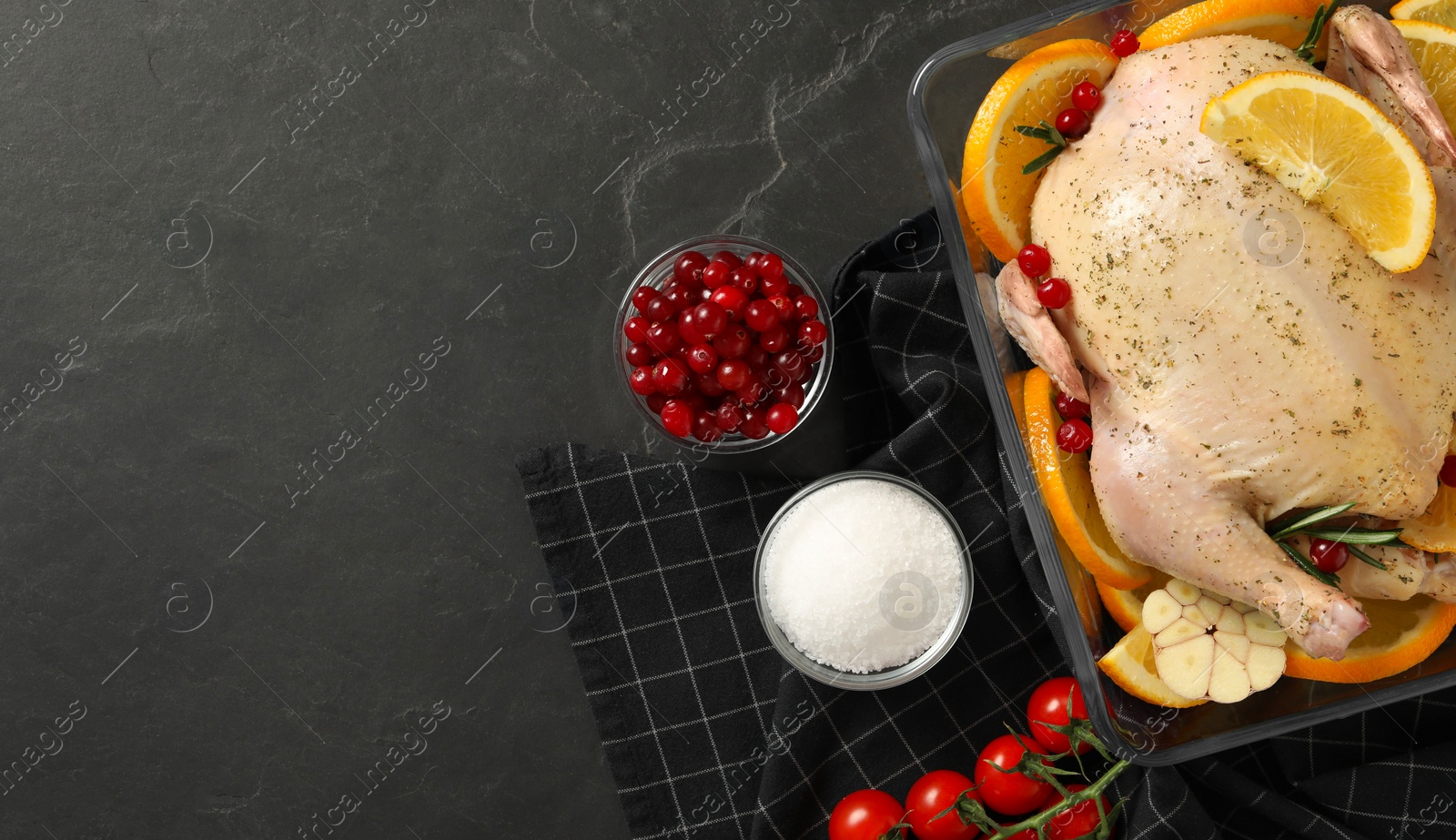 Photo of Flat lay composition with chicken, orange slices and ingredients on dark grey table. Space for text