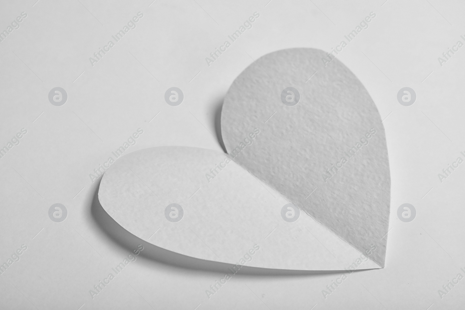 Photo of Heart shaped paper cutout on white background