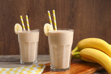 Photo of Glasses with banana smoothie on wooden table
