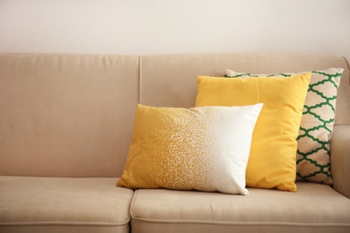 Photo of Different soft pillows on sofa in room