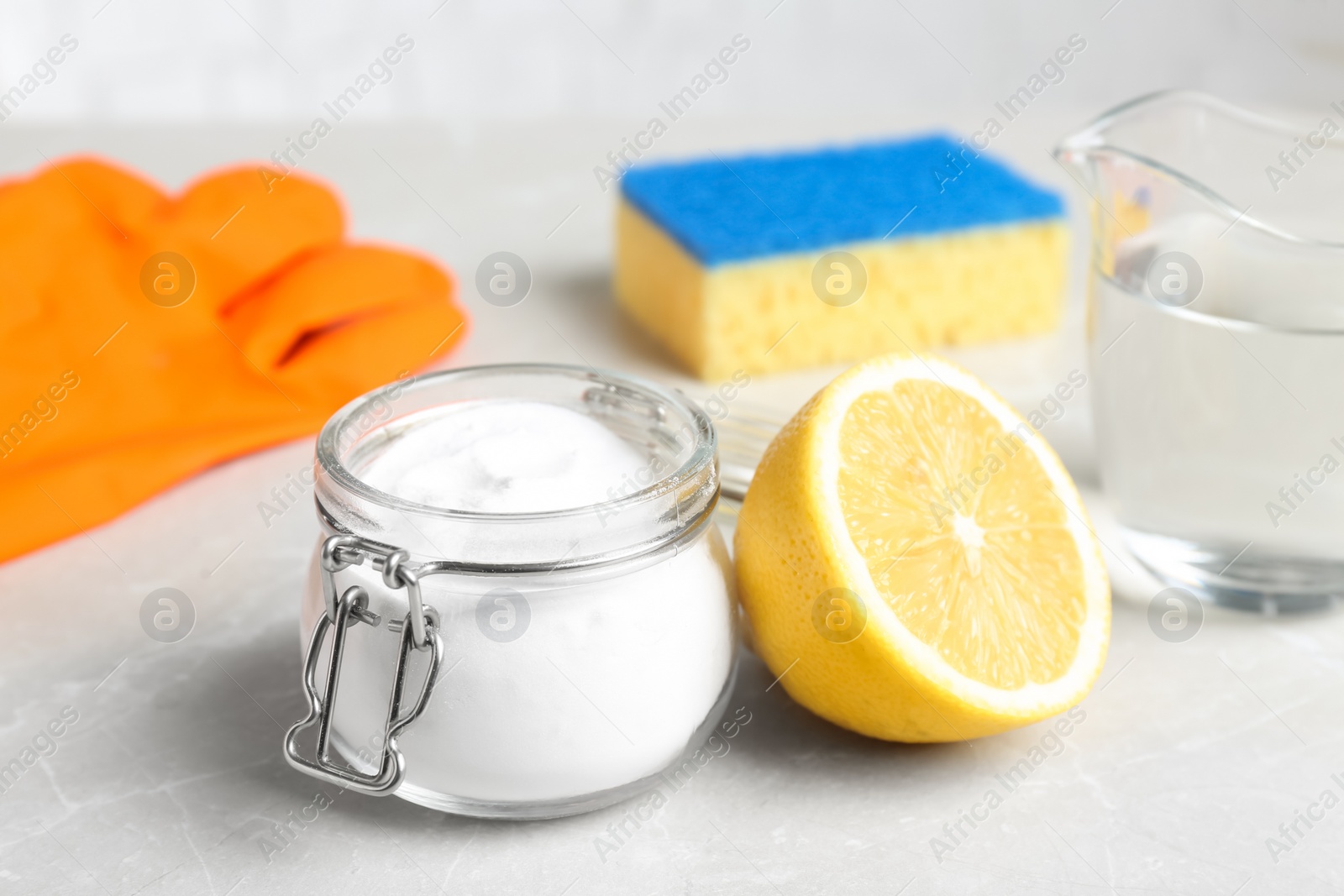 Photo of Baking soda and cut lemon on light grey table