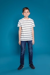 Full length portrait of cute boy on color background