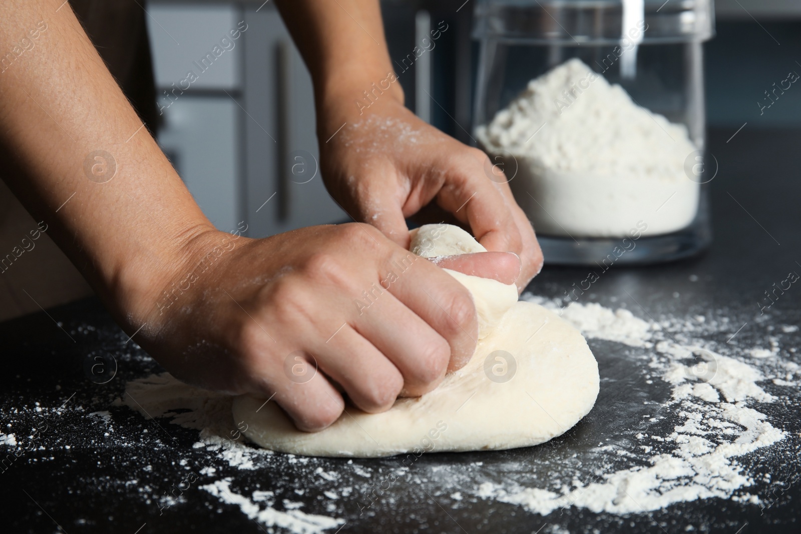 Photo of Woman kneading dough for pastry on table