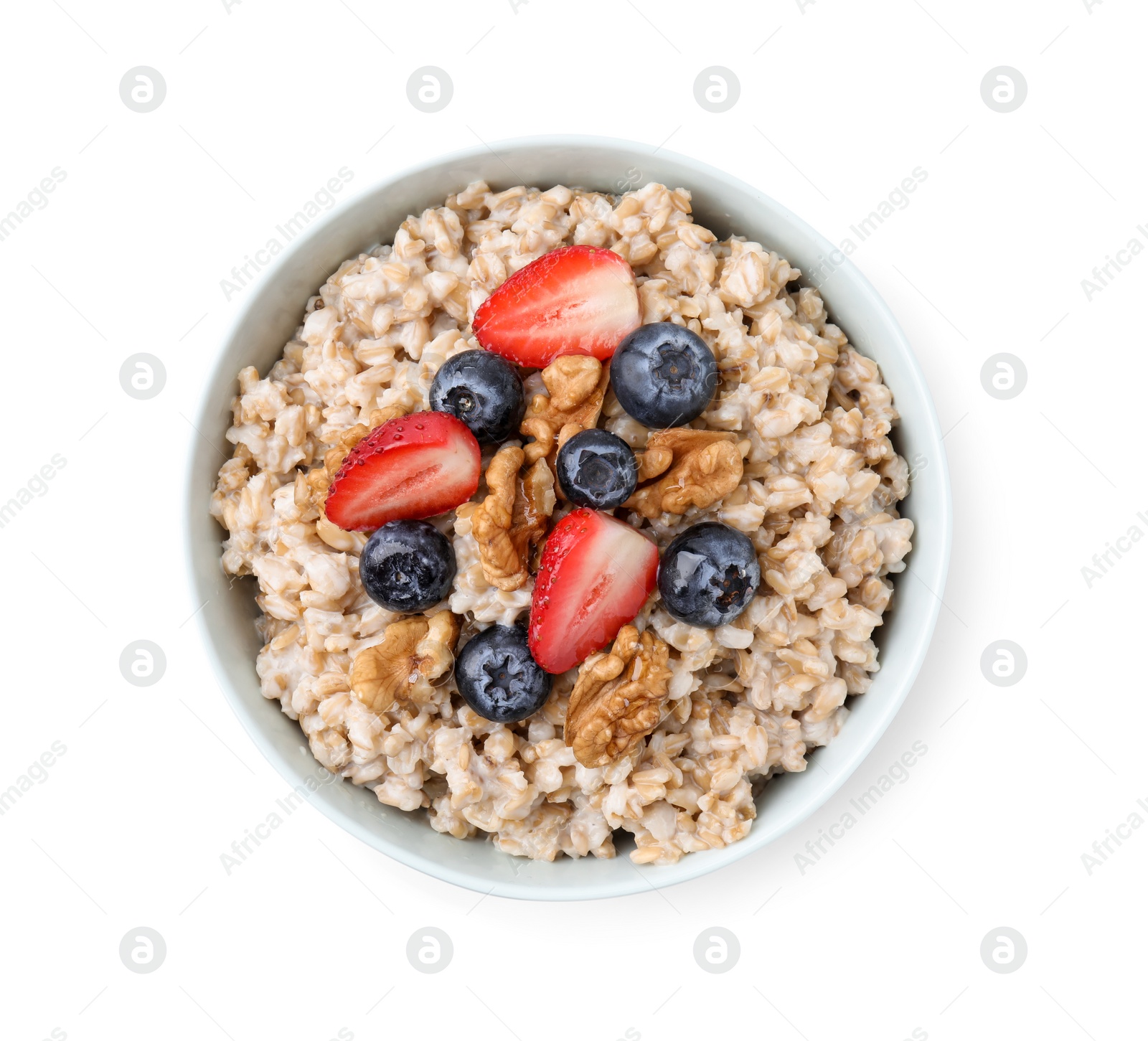 Photo of Tasty oatmeal with strawberries, blueberries and walnuts in bowl isolated white, top view