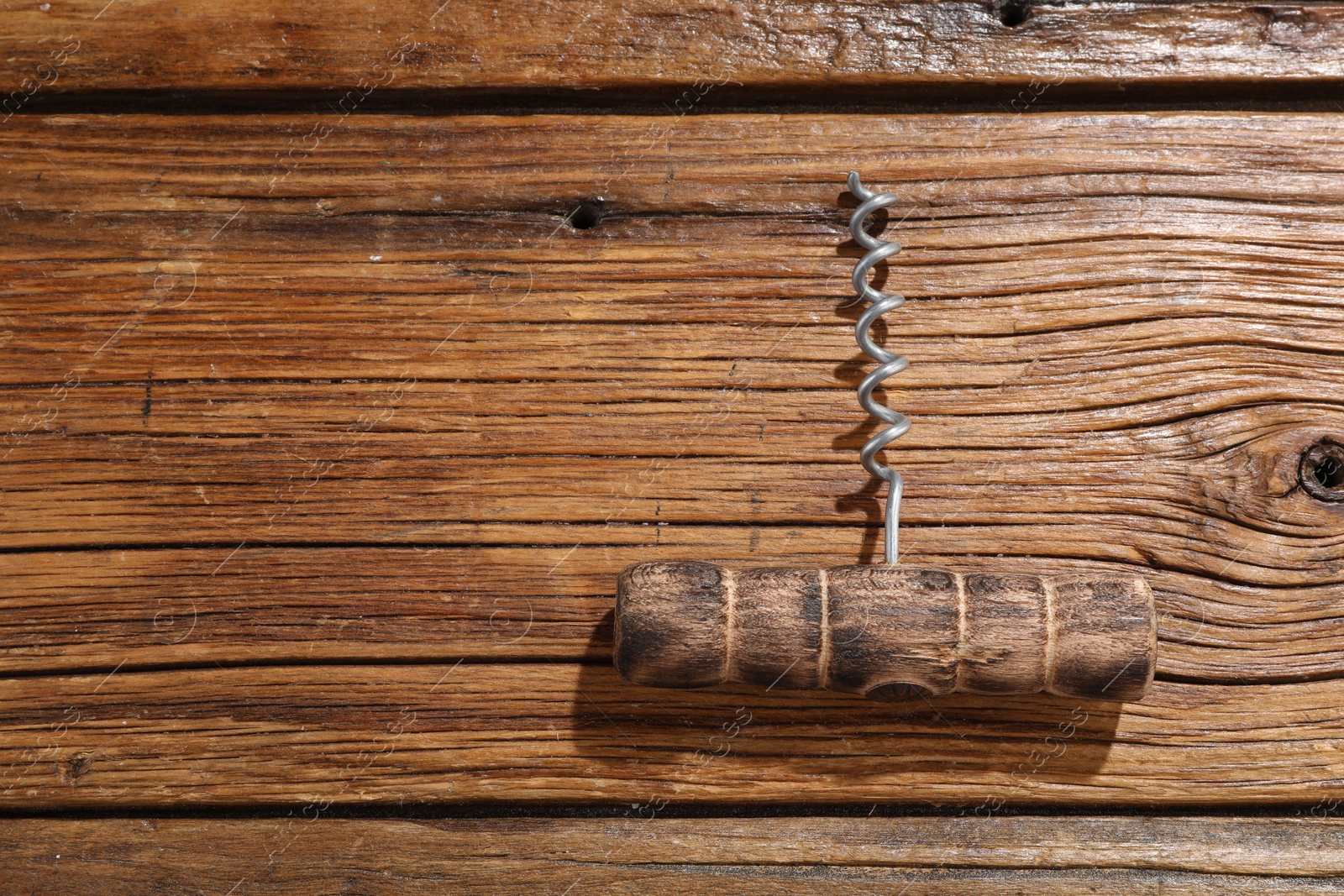 Photo of One corkscrew on wooden table, top view. Space for text